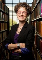 Professor Leslie Reagan, standing in her office. 2 book-cases in the background 