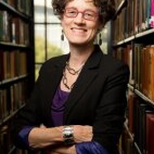 Professor Leslie Reagan, in front of stacks of books 